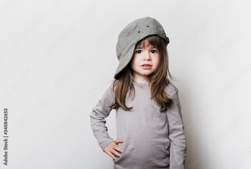 Une petite fille avec une casquette trop grande pour sa tête Une petite fille avec une casquette trop grande pour sa tête