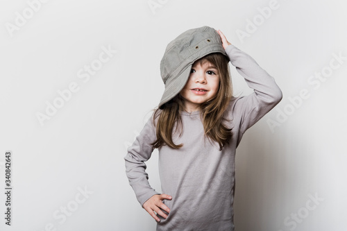 Une petite fille avec une casquette trop grande pour sa tête