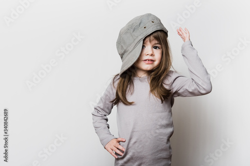 Une petite fille avec une casquette trop grande pour sa tête