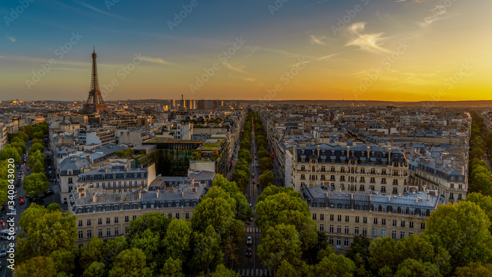 Paris sunset skyline aerial view from top of Arc de Triomphe on Champs Elysees street. Distant Tour Eiffel tower Landmark in Paris, France, Europe.