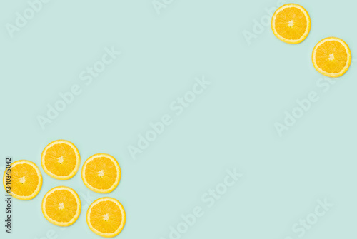 a selection of cut oranges laid out on a light green background with a place for inscription