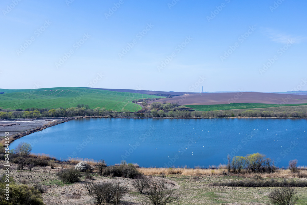  Picturesque landscape. Lake and green hill