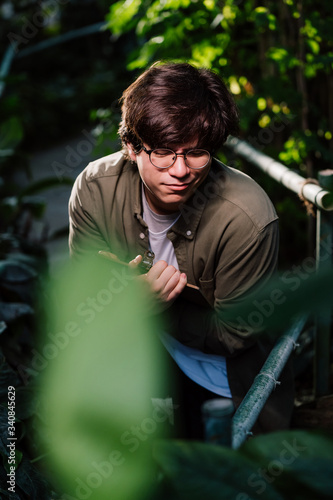 Male scientist hiding in the thicket. Nature protection concept.