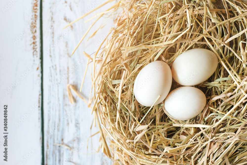 Top view of fresh organic white eggs on nest hay on dark grunge background with copy space. Top view of fresh organic white eggs on nest hay on dark grunge background with copy space.