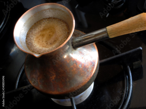Barista preparing hot tasty drink from copper turk