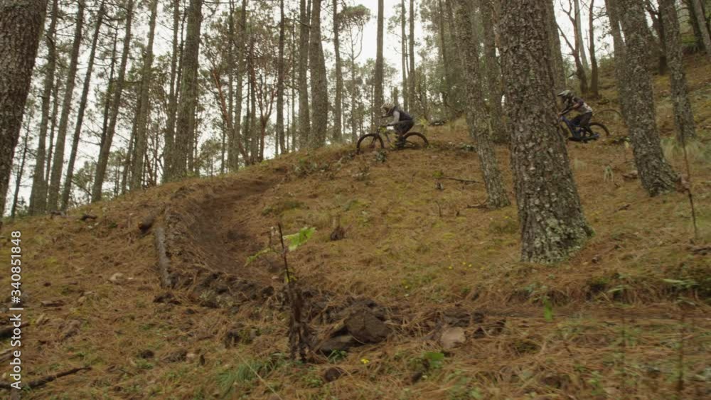 TWO MOUNTAIN BIKE RIDERS GOING DOWN THE MOUNTAIN IN SLOW MOTION TWO MOUNTAIN BIKE RIDERS GOING DOWN THE MOUNTAIN IN SLOW MOTION
