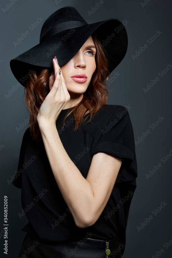 Portrait of a woman in a large black hat on a dark background Portrait of a woman in a large black hat on a dark background