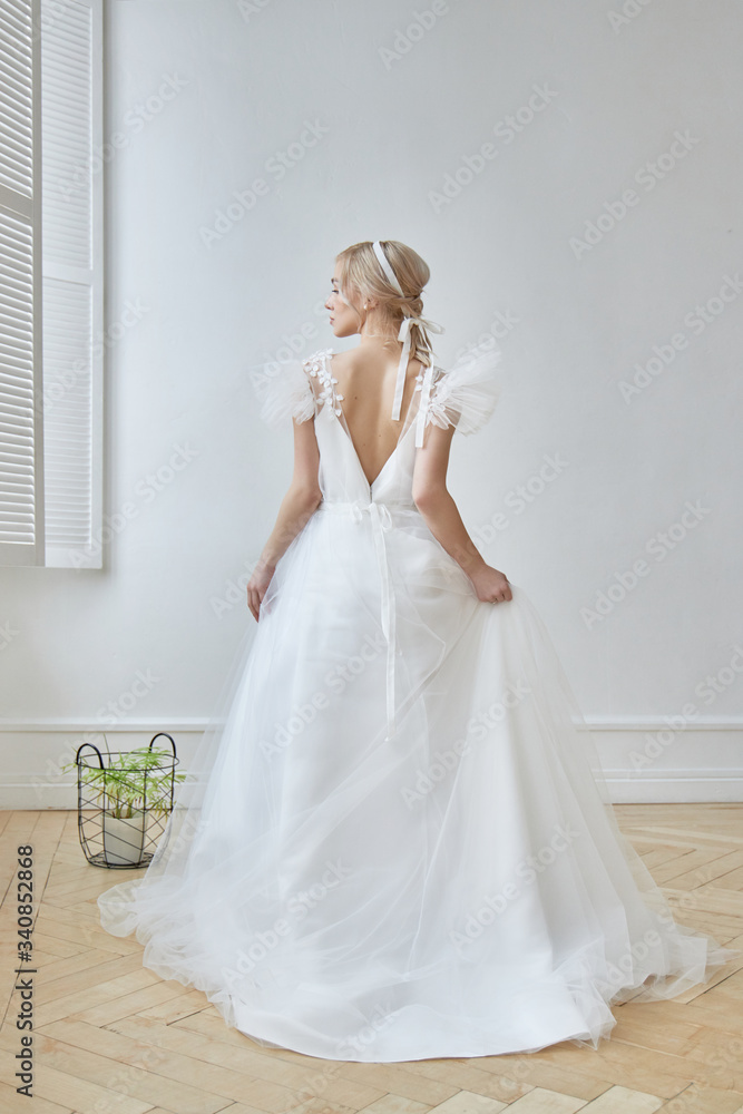 Luxurious white wedding dress on the girl's body. New collection of wedding dresses. Morning bride, a woman waiting for the groom before the wedding ceremony. Young bride in a long dress Luxurious white wedding dress on the girl's body. New collection of wedding dresses. Morning bride, a woman waiting for the groom before the wedding ceremony. Young bride in a long dress