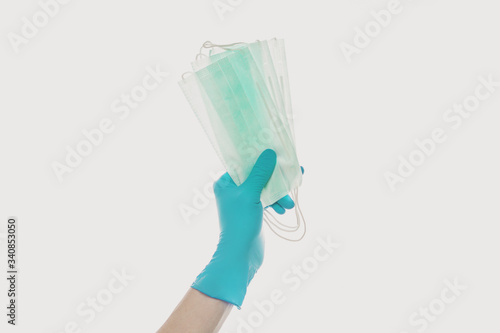 Face mask in doctor hand on light gray background, safety and virus protection concept