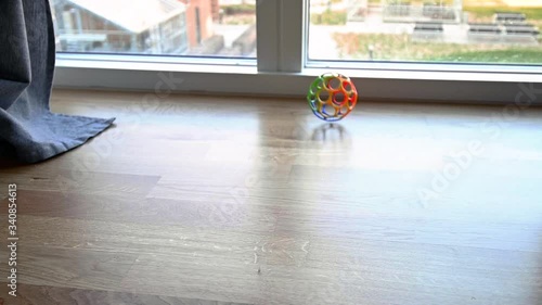 Colourful toy plastic ball rolling over the floor in slow motion, stock footage by Brian Holm Nielsen photo