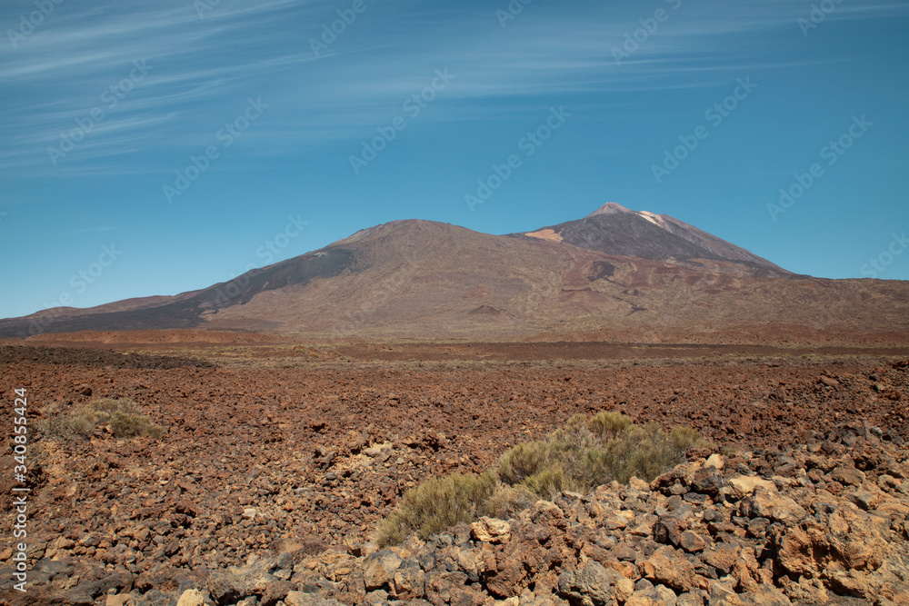 Pico del Teide and Pico Viejo in Teide National Park surrounded by the arid landscape created by volcanic eruptions: igneous rocks, solidified lava and volcanic ash, in Tenerife, Canary Islands, Spain