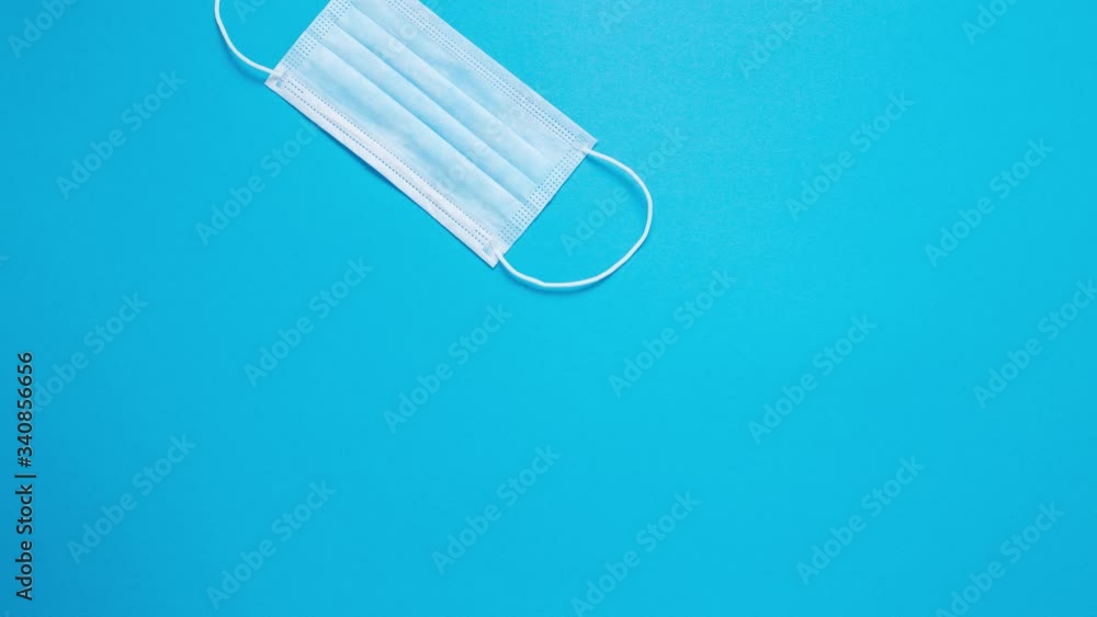 Stop motion. Medical mask on a blue isolated background close-up. Stop motion. Medical mask on a blue isolated background close-up.