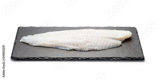 Basa fish fillet on a black stone plate, Isolated on white background. photo