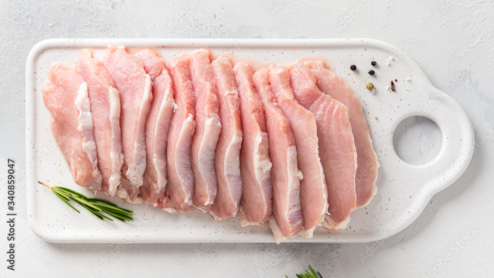 Raw pork meat. Fresh steaks on white board on white background. Top view. Dieting, nutrition Raw pork meat. Fresh steaks on white board on white background. Top view. Dieting, nutrition