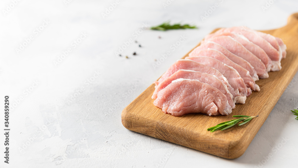 Fresh pieces pork ready to cook on wooden board on a white background. Sirloin medallions steaks in a row ready to cook. Side view, copy space. Butcher shop Fresh pieces pork ready to cook on wooden board on a white background. Sirloin medallions steaks in a row ready to cook. Side view, copy space. Butcher shop