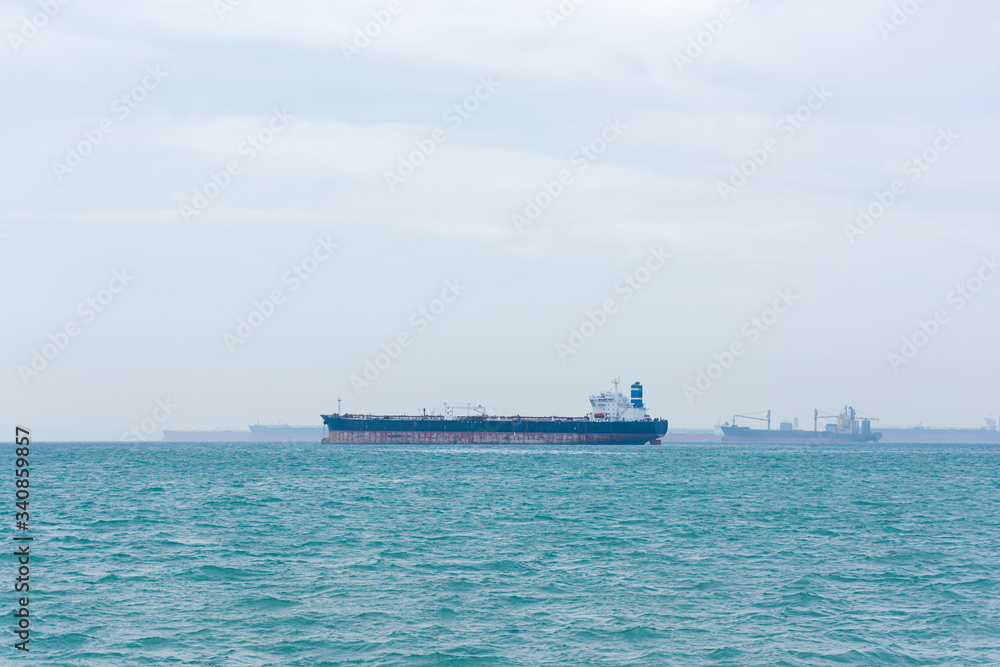 Cargo ships and oil tankers anchored offshore along the Singapore Straight, in Singapore Cargo ships and oil tankers anchored offshore along the Singapore Straight, in Singapore