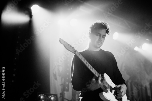 Guitarist playing electric guitar in a rock concert photo