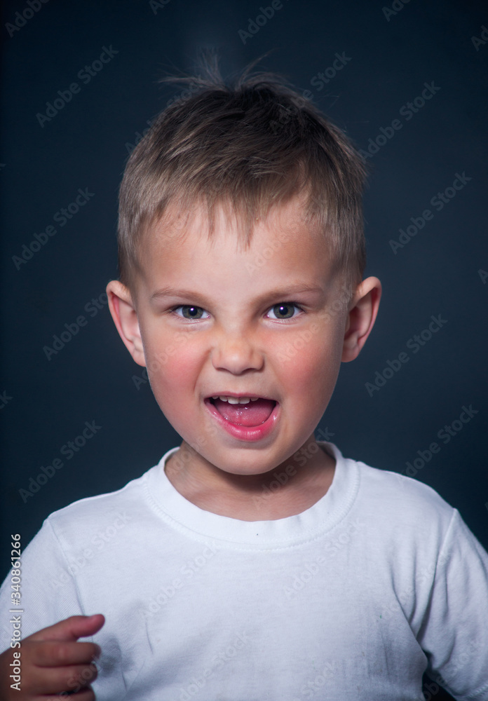 offended and nervous boy on gray background offended and nervous boy on gray background