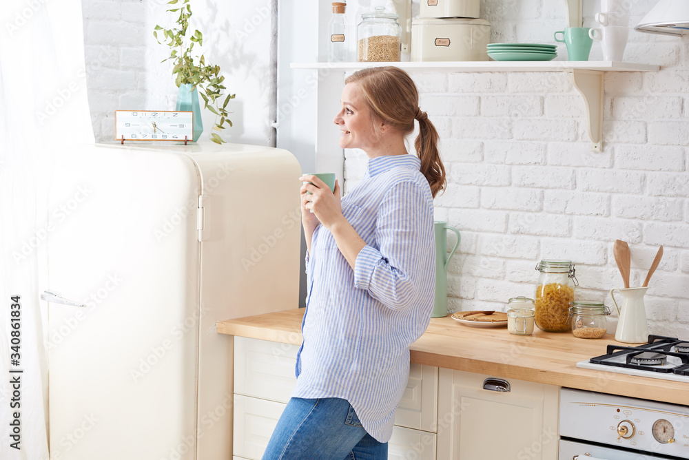 Portrait of smiling young housewife in modern kitchen Portrait of smiling young housewife in modern kitchen