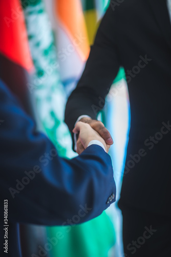Business people shake hands, international flag background © chokniti