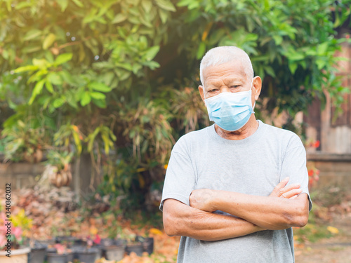 Portrait of elderly man with short white hair, wearing face mask for health because have air pollution PM 2.5. Mask for protect virus, coronavirus, bacteria, pollen grains. Health care concept