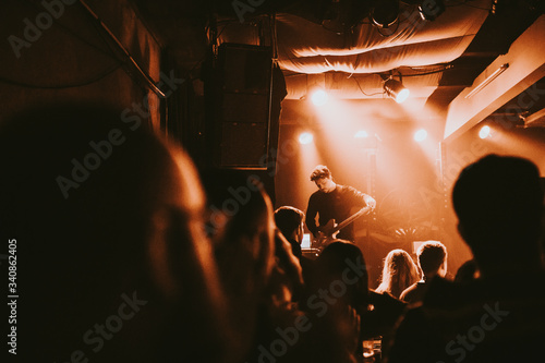 Guitarist playing an electric guitar in a concert photo