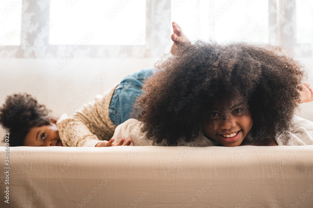 African American children relax playing on the bed at home African American children relax playing on the bed at home