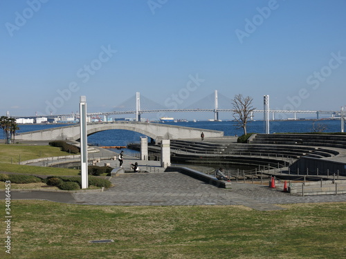 横浜市西区みなとみらいの臨港パークにある潮入りの池とアーチ橋（背景は横浜港・横浜ベイブリッジ）