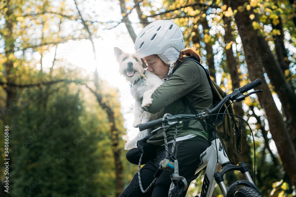 19/4/2020 Asian woman with a bike kissing with a dog in autumn at the Botanic garden, Oamaru, New Zealand. Concept about exercise while social isolation from Coronavirus or Covid 19. With copy space. 19/4/2020 Asian woman with a bike kissing with a dog in autumn at the Botanic garden, Oamaru, New Zealand. Concept about exercise while social isolation from Coronavirus or Covid 19. With copy space.