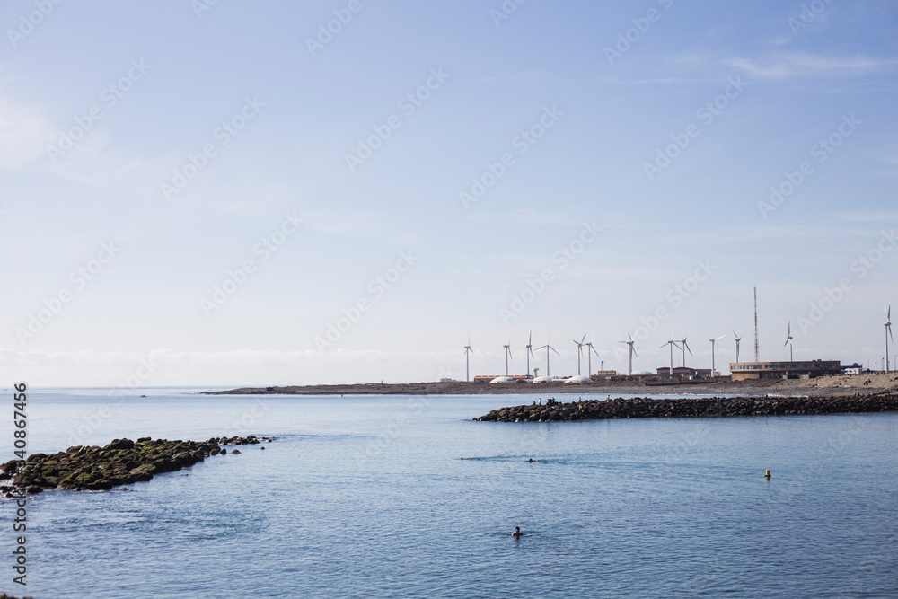 beach with windmills in the background