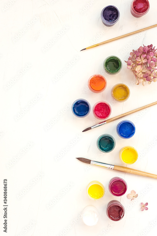 Acrylic paints and brushes at white background. Flat lay, top view Acrylic paints and brushes at white background. Flat lay, top view