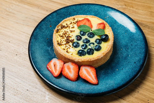 small tart with berries, Bizet on a plate with slices in a cafe
