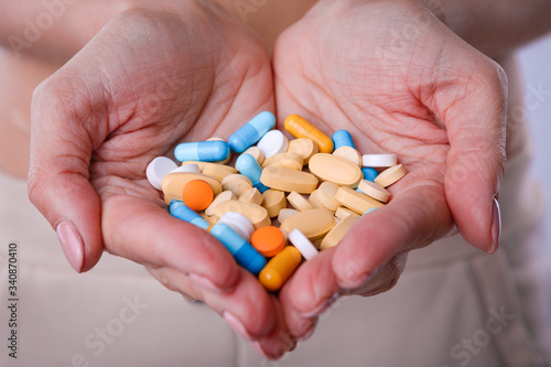 A handful of colored pills in the hands.