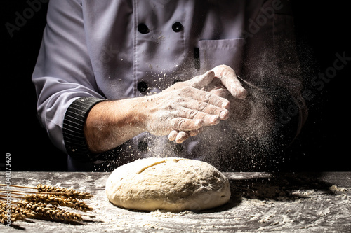 Fototapeta Naklejka Na Ścianę i Meble -  Preparing traditional homemade bread. Close up view of baker kneading dough. Homemade bread. Hands preparing bread dough on wooden table