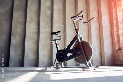 Fotografija Exercise bike on concrete wall background in gym