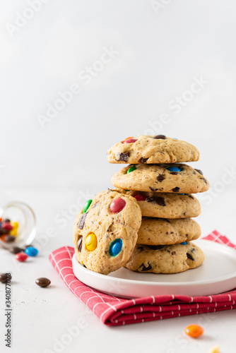 Stack of Homemade vanilla cookies decorated with multi-colored candy drops on white background. Side view, close up