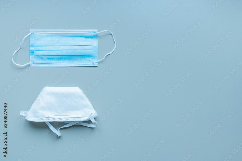Medical face masks and respirator on blue background. Protection against viruses and diseases Medical face masks and respirator on blue background. Protection against viruses and diseases