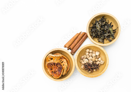 Dry Bale fruit and green tear with spice in round wooden bowl on white background, Thai herb, health and medical concept