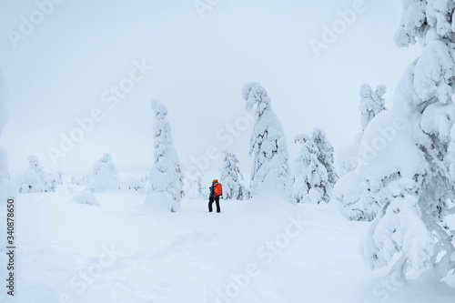 Landscape photographer trekking in a snowy Lapland, Finland