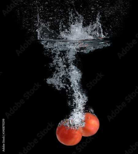 Tomatoes falling into the water