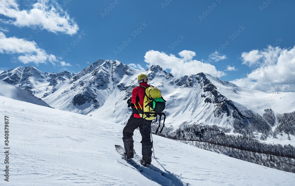 Active man with backpack ski touring at mountains background in Caucasus, Russia Active man with backpack ski touring at mountains background in Caucasus, Russia