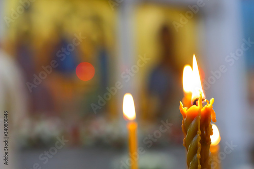 Candles are lit on the background of icons of the Orthodox Church. Blurred long-range plan. The concept of Orthodox faith.