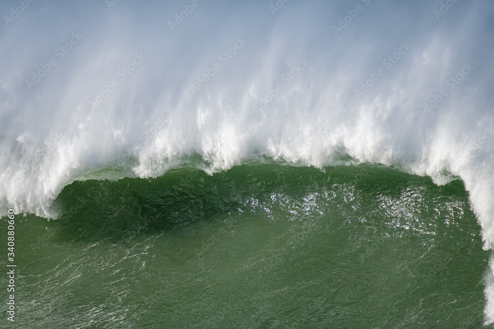 Naklejka premium A big wave crashing in the coast. Plenty of blank space.