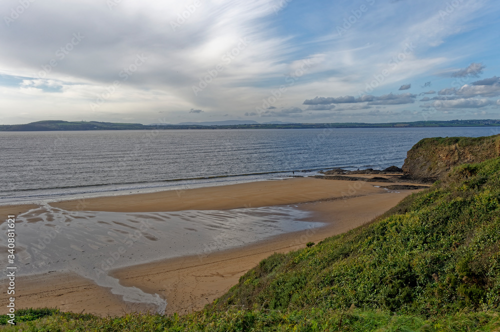 The small sandy beach of Sandeel bay on the coast of County Wexford on a quiet October afternoon.