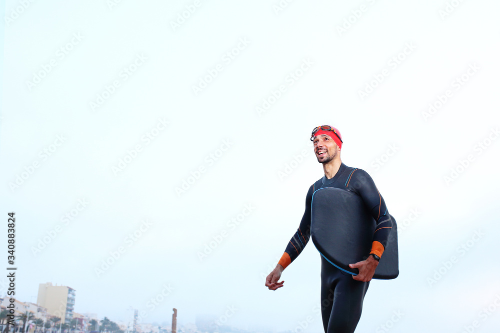 Skimboard, man swims on the board. A man in thermal foam does water sports in the sea. Skimboard, man swims on the board. A man in thermal foam does water sports in the sea.