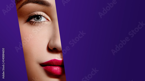 Woman face with plump red lips in violet paper frame. Young model. Close up beauty photo. Geometry and minimalism. Creative fashion makeup, beautiful woman, clear skin
