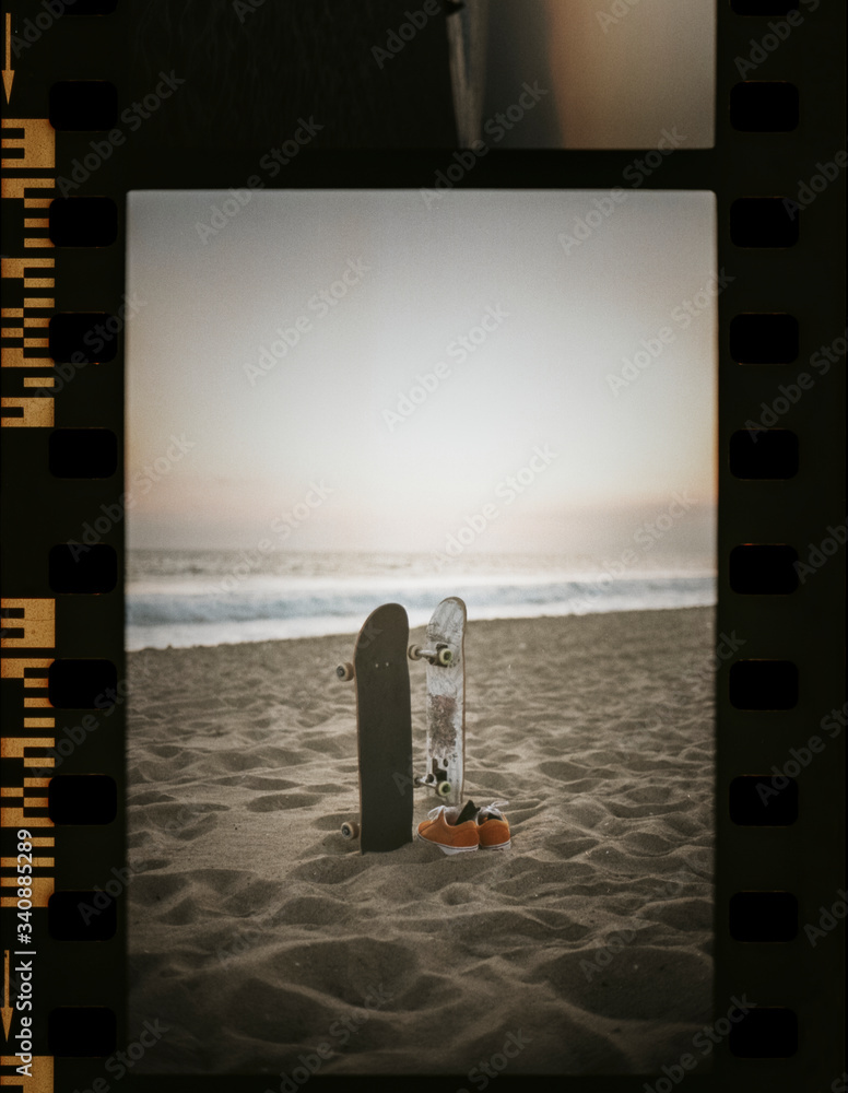 Skateboards at the beach in a film strip - obrazy, fototapety, plakaty 