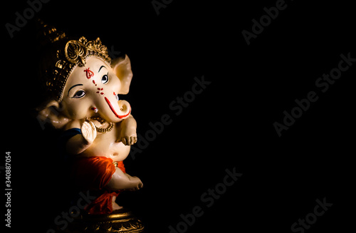 low light photography of beautiful ganesha statue on black background. worship concept photo