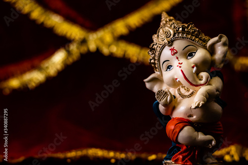 Photography low angle photography of beautiful ganesha statue on red and golden background with copy space in left
