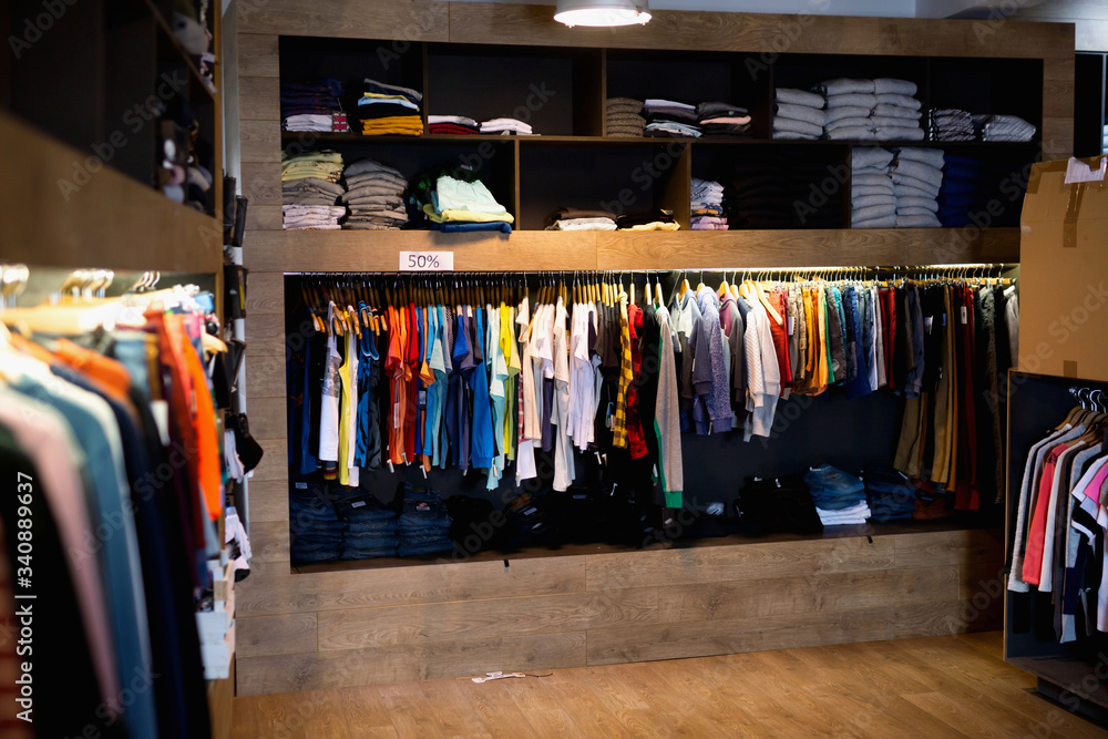 Men clothing shop,  casual clothes on hangers and shelves in apparel store
